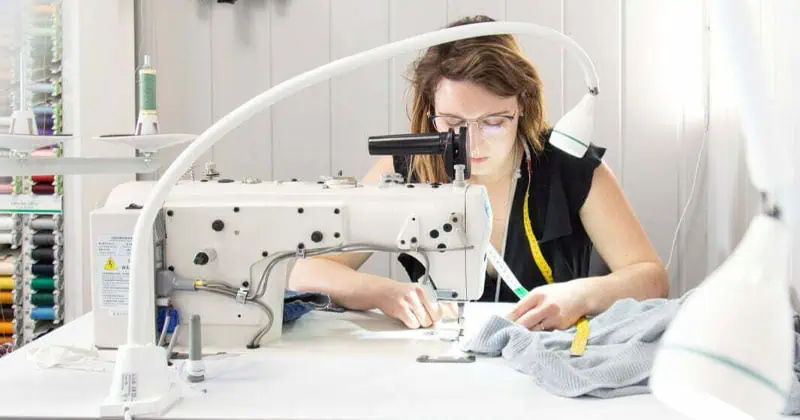 Couturière travaillant dans l'atelier Retoucherie Misha